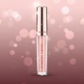 Lumère Cristal liquid lip gloss in a clear tube showing pink glitter gloss inside, topped with a metallic rose gold cap, on a white background with a soft reflection.